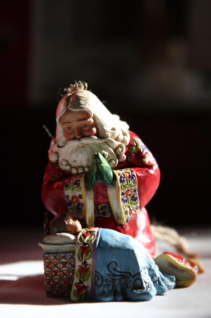 Santa Claus kneels before the Christ child
